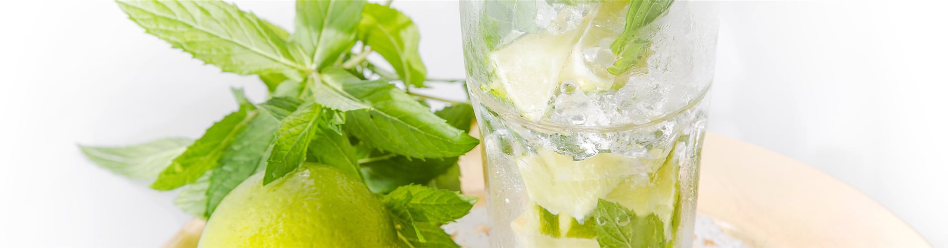 Ein Glas Mojito, links daneben eine Zitrone Ein Glas Mojito, links daneben eine Zitrone