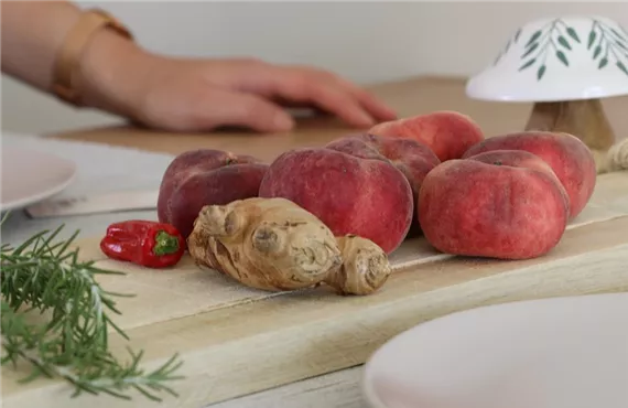Pfirsiche, Ingwer, Chili und Rosmarin auf einem Schneidebrett Pfirsiche, Ingwer, Chili und Rosmarin auf einem Schneidebrett