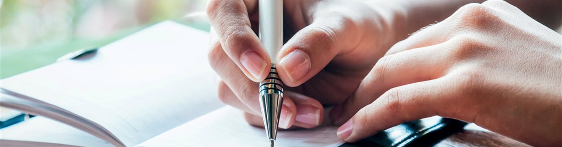 Person die Notzien in ein kleines Heft schreibt Person die Notzien in ein kleines Heft schreibt